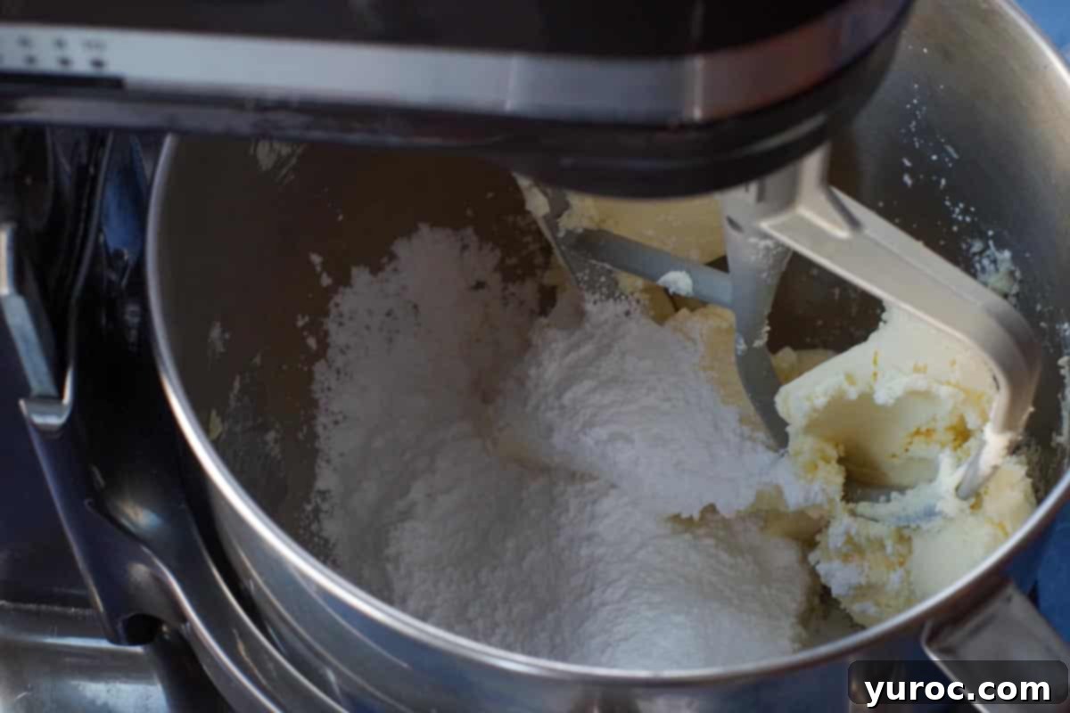 butter being creamed with icing sugar in stand mixer