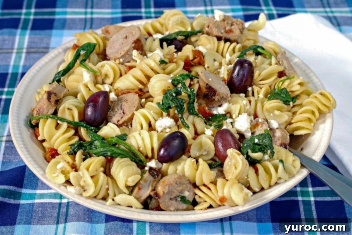 Sun-Kissed Aegean Pasta 2 Greek pasta in a blue bowl with a brown wooden spoon, garnished with fresh herbs and a lemon wedge.