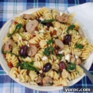 Sun-Kissed Aegean Pasta 11 Mediterranean past in a bowl with spoon and white napkin on the side