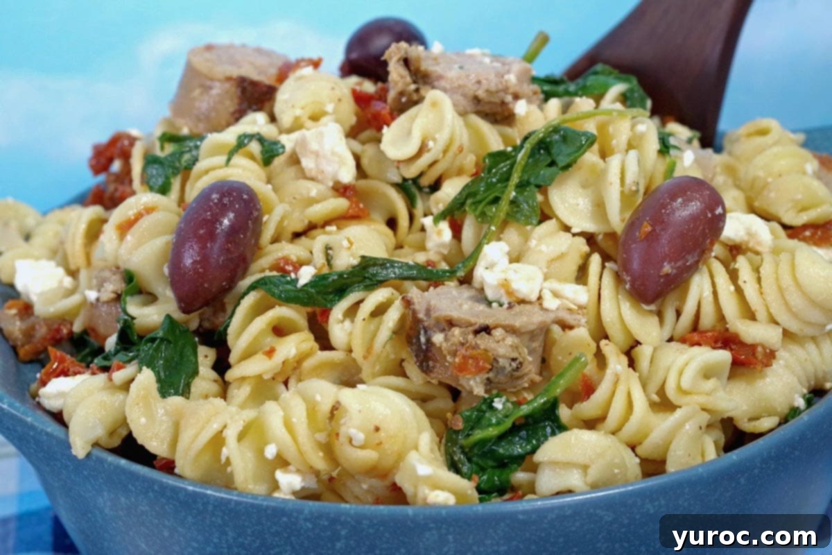 Sun-Kissed Aegean Pasta 4 Greek pasta in a blue bowl with a brown wooden spoon, ready to be served.