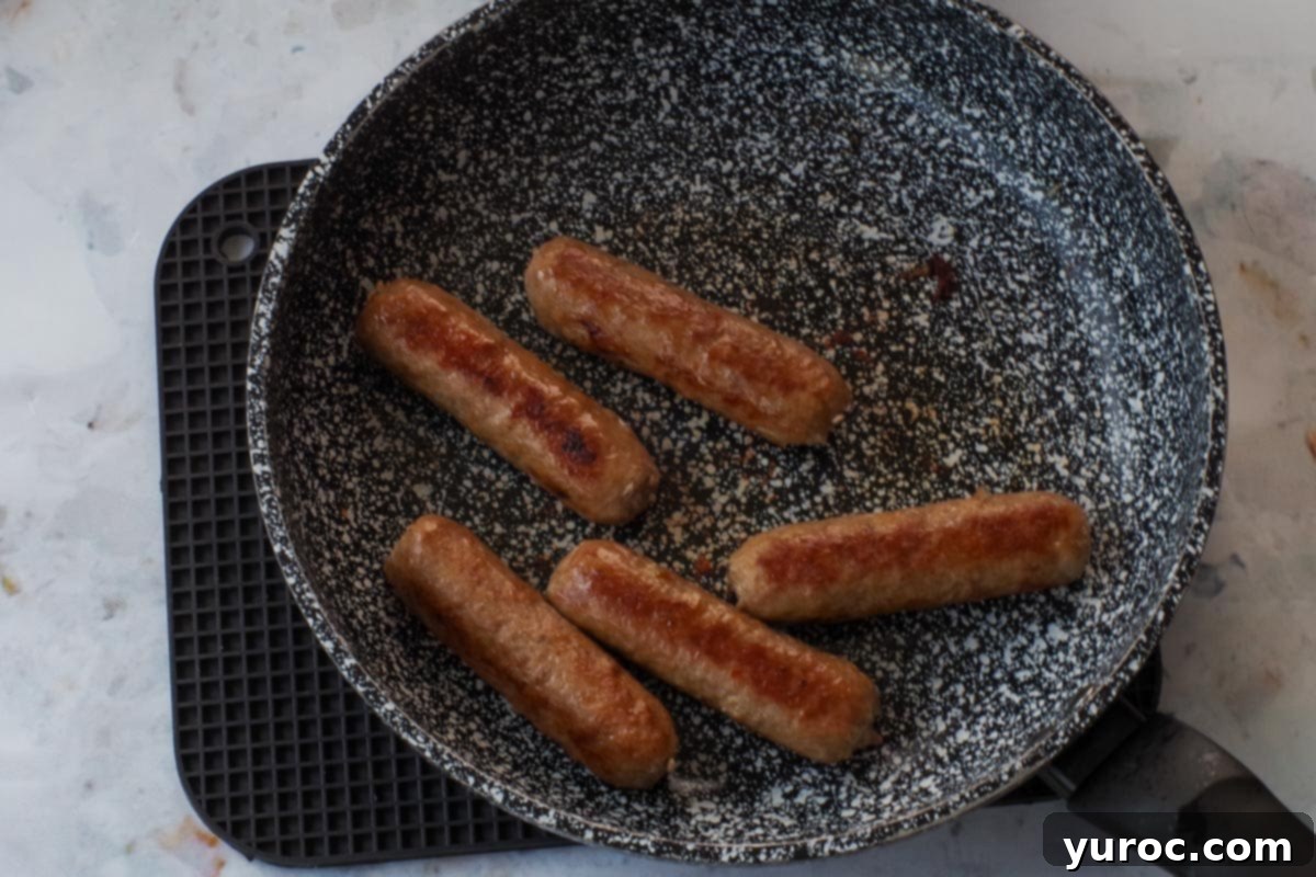 Sun-Kissed Aegean Pasta 5 Turkey sausage being cooked in a frying pan until no longer pink.