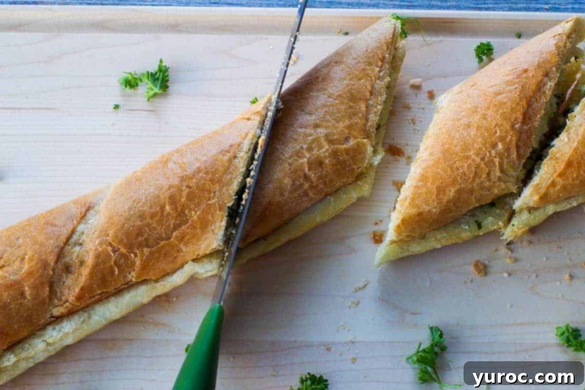 Sun-Kissed Aegean Pasta 9 A baguette being cut with a bread knife on a wooden cutting board, with fresh herbs and a cloth napkin nearby.