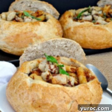 Three sourdough bread bowls brimming with Panzanella Pasta Soup, two of which are presented on a black serving tray.