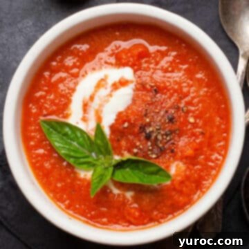 Fresh and vibrant Easy Tomato Basil Soup served in a white bowl, garnished with fresh basil leaves.