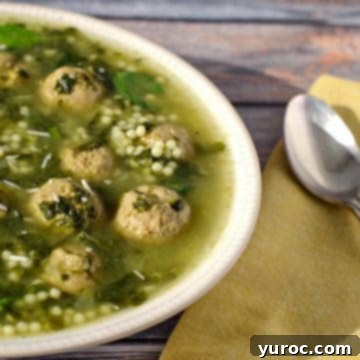 Easy Italian Wedding Soup with frozen meatballs, served in a bowl on a bluish wooden background with a yellow napkin and spoon.
