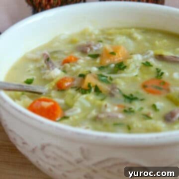 Traditional Scotch Broth (Scottish Soup) served in a white bowl with a spoon, highlighting the hearty vegetables and broth.