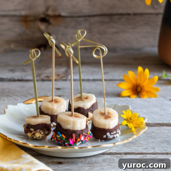 Assorted chocolate-covered frozen fruit pieces, glistening with a hardened chocolate shell.