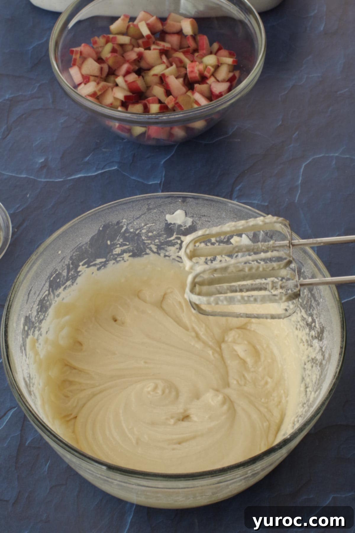 ingredients for cake mixed in glass bowl , beaten with hand mixern