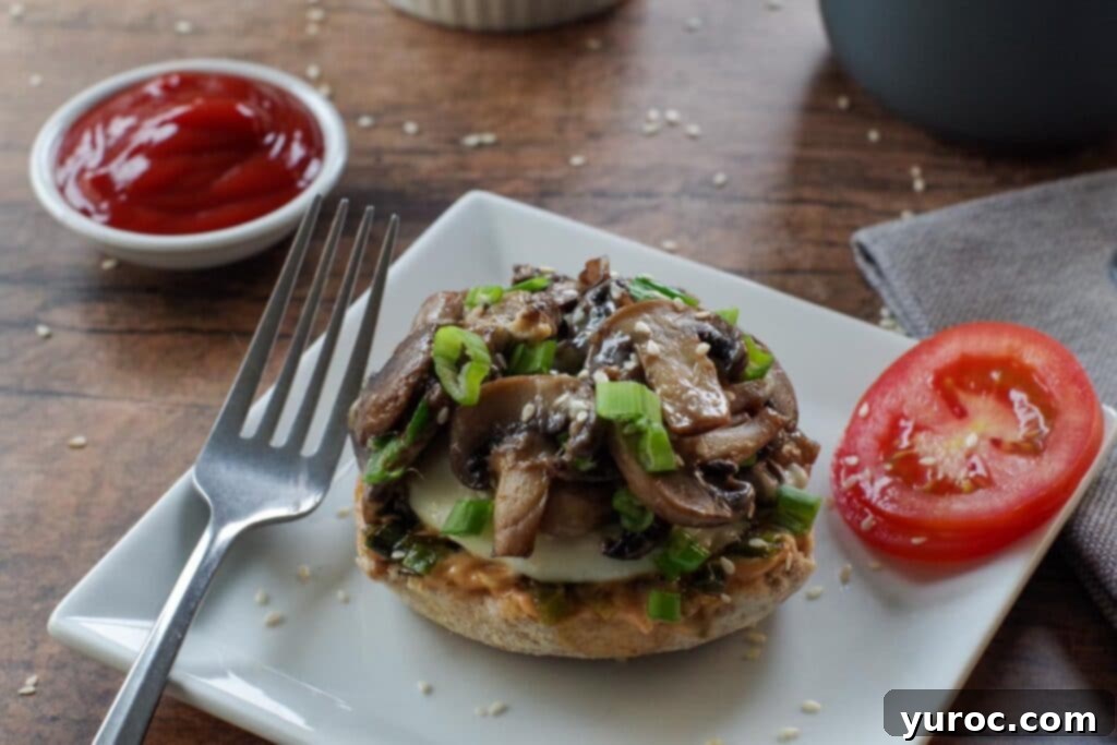 Open-faced Breakfast Mushroom Melt with a fried egg and melted mozzarella cheese, garnished with green onions and sesame seeds.