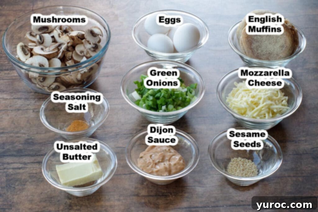 A selection of fresh ingredients laid out: Cremini mushrooms, green onions, eggs, mozzarella cheese, English muffins, and sauce ingredients.
