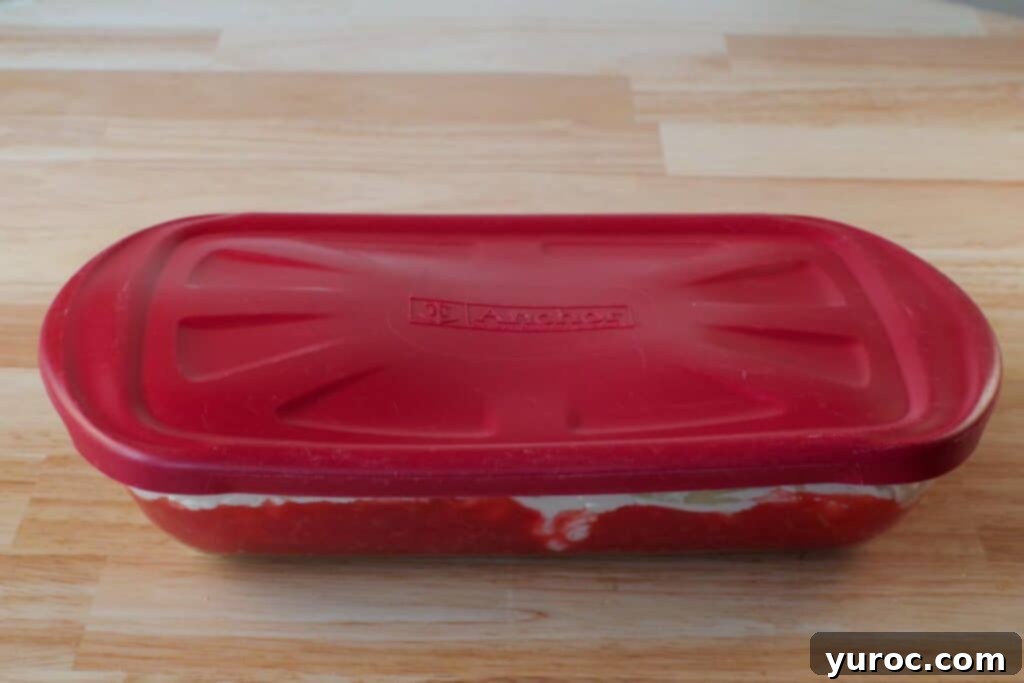 No-Bake Rhubarb Delight 13 glass 9X13 pan with red plastic lid on counter
