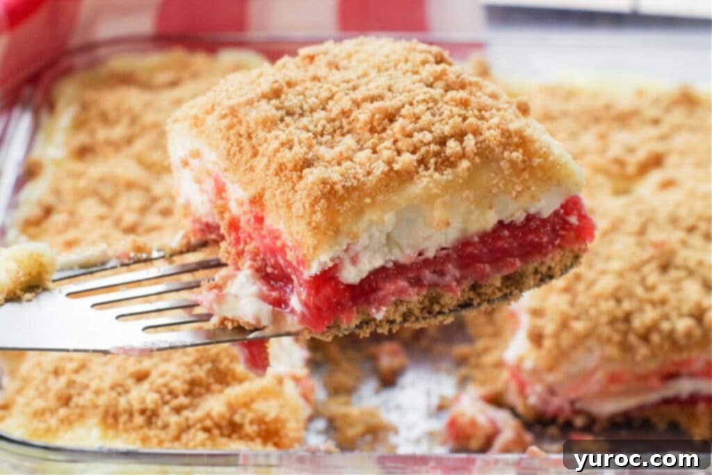 No-Bake Rhubarb Delight 14 piece of rhubarb dessert being held up with spatula (over pan full of more rhubarb dessert)