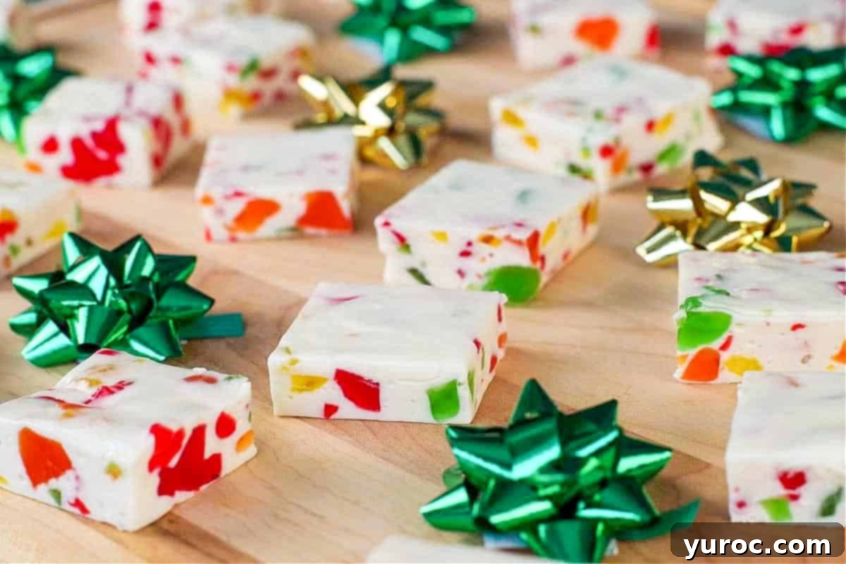 Nougat candy, cut into squares, on a wooden cutting board with green and gold mini bows, showcasing its colorful appearance
