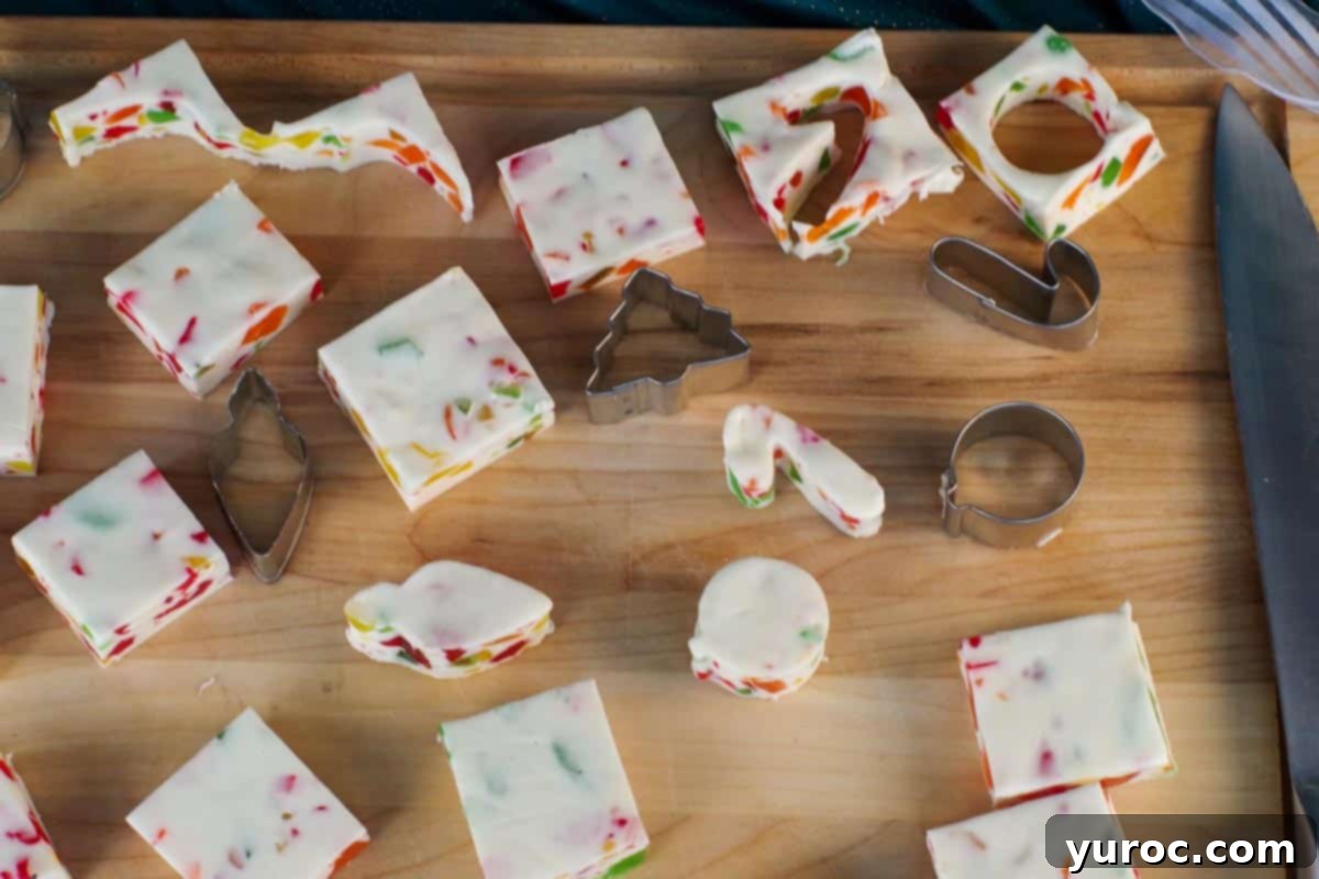 nougat cut into Christmas shapes (candy cane etc) with square s on a wooden cutting board with mini cookie cutters