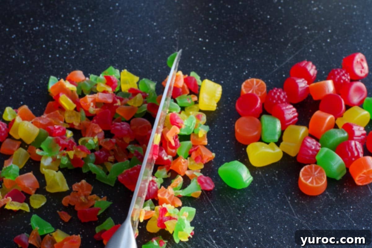 jujubes being chopped into smaller pieces on a black cutting board