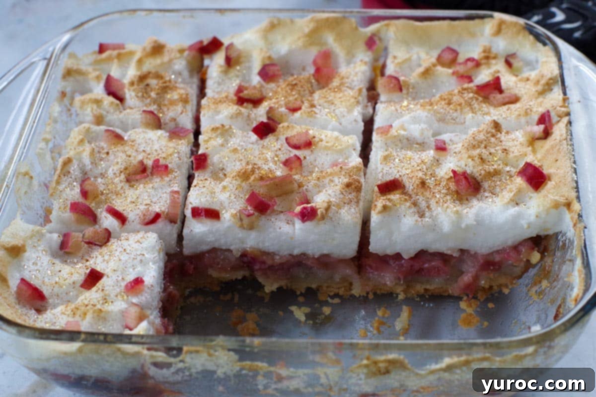 rhubarb torte in a glass pan with 2 pieces missing
