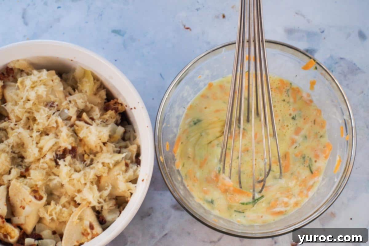 Sour cream, hot mustard, eggs, dill, and 1 cup of cheddar cheese medium whisked together in a medium glass mixing bowl with whisk, beside casserole dish. A creamy, yellow egg mixture ready to bind the casserole.