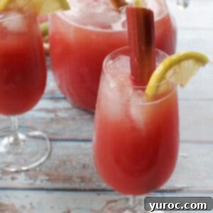 Effortless Rhubarb Lemonade 9 rhubarb lemonade in a glass with a pitcher and another glass in the background
