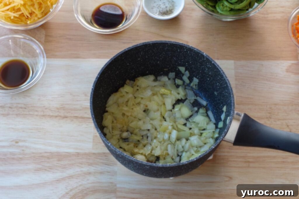 Sautéed onions, butter, and minced garlic cooking in a large pot on the stovetop.
