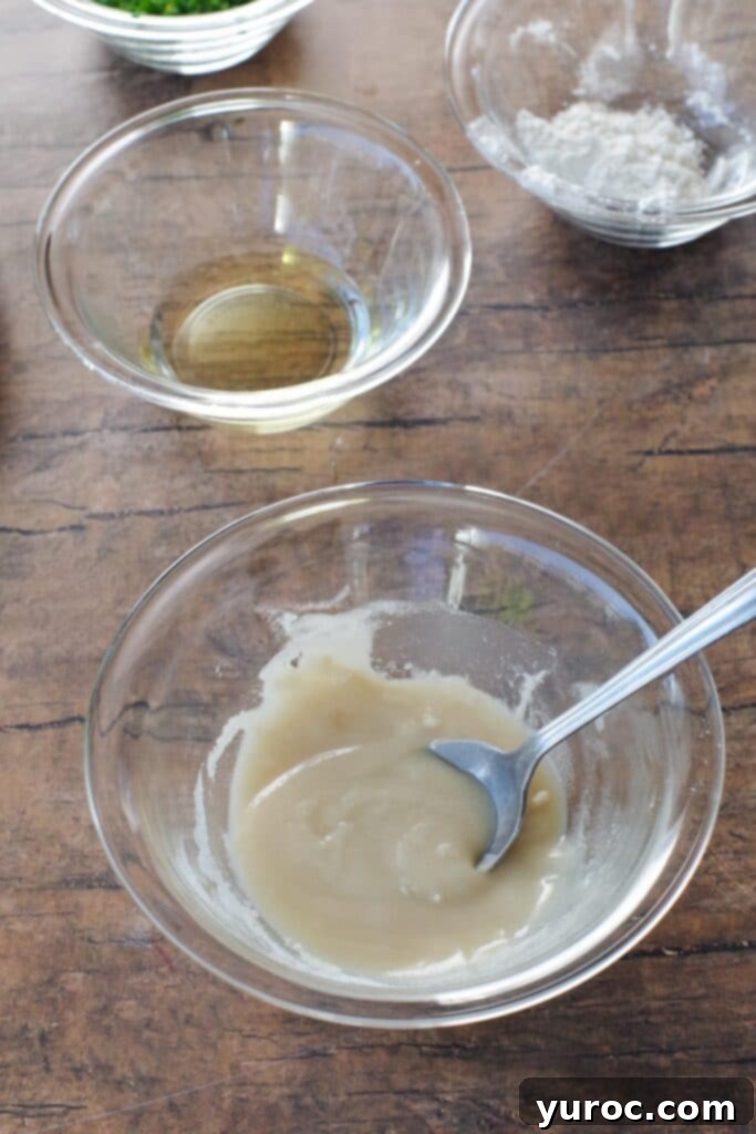 Effortless Beer Cheese Soup 5 A small glass bowl containing a pale, thick paste, illustrating the roux mixture of flour and oil before it is added to the soup. The image emphasizes the smooth consistency needed for thickening.