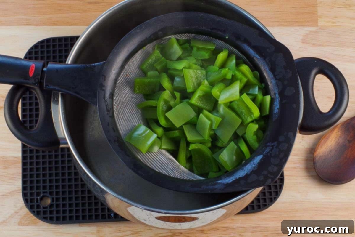 Chopped and cooked green pepper in a sieve.