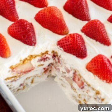 strawberry icebox cake in a white rectangular dish (with a piece missing)