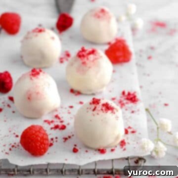 white raspberry truffles on a parchment lined wire rack