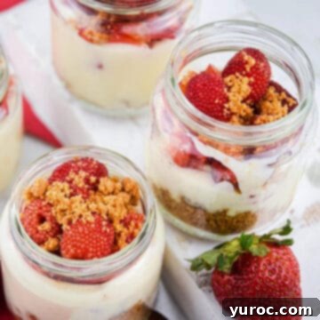 raspberry cheesecake shots in jars on a white surface