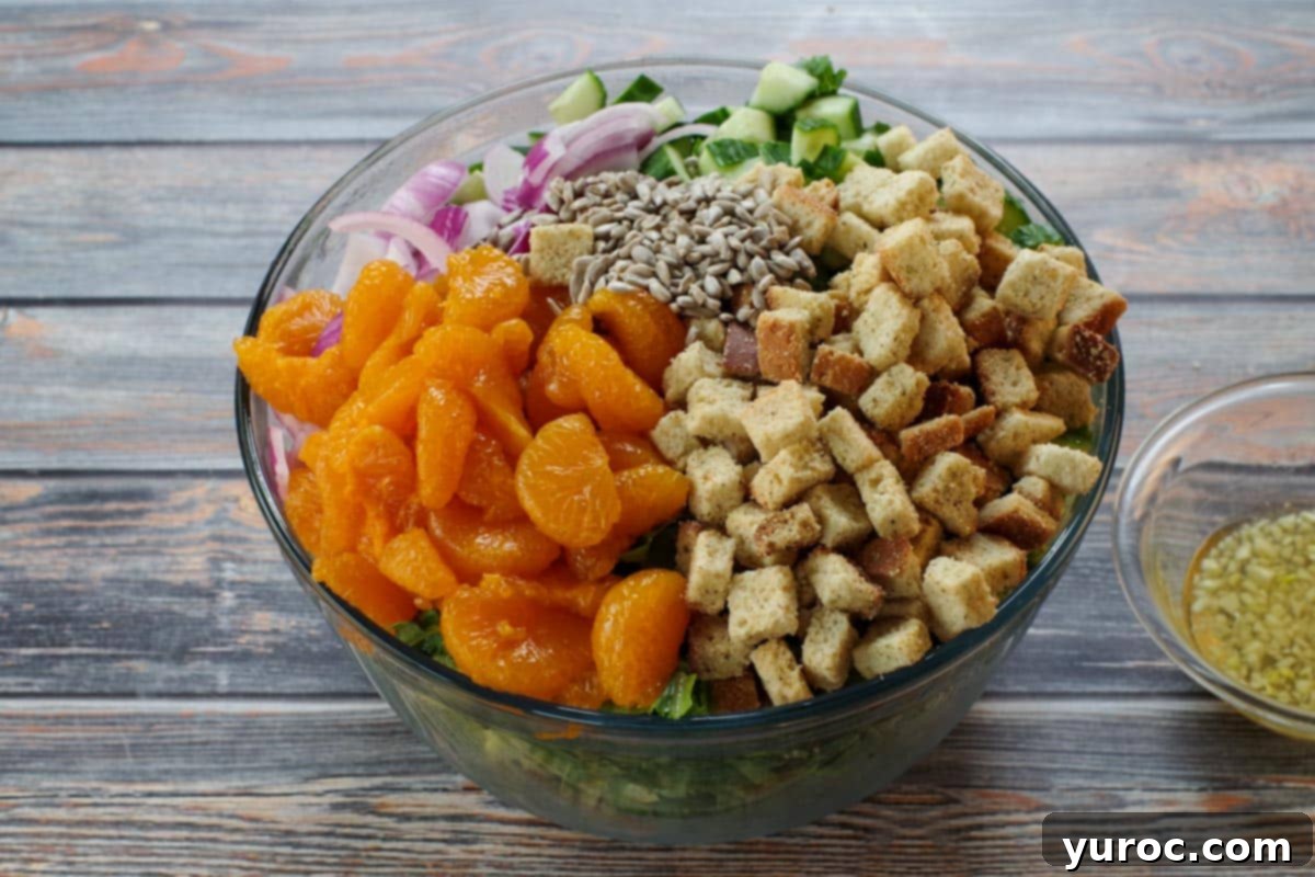 Mandarin orange salad ingredients arranged in a large bowl