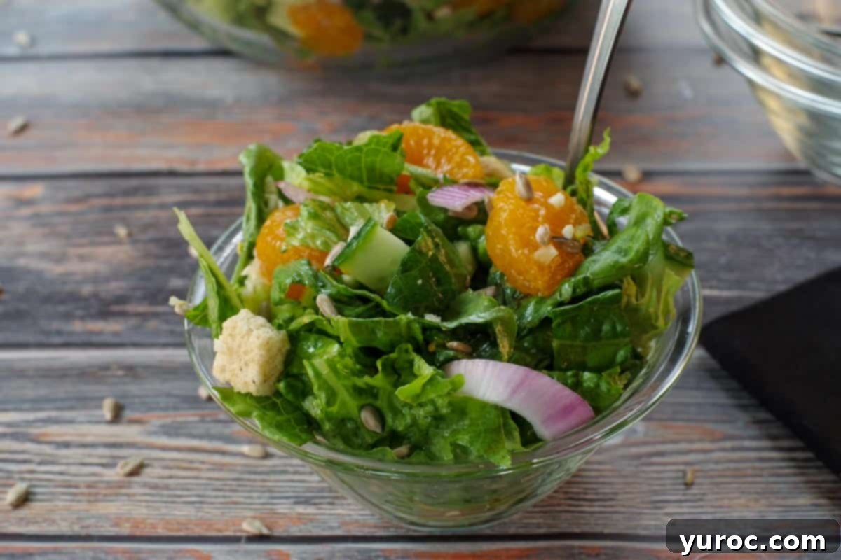 Mandarin Orange salad in a small glass bowl with a fork, highlighting its appeal.