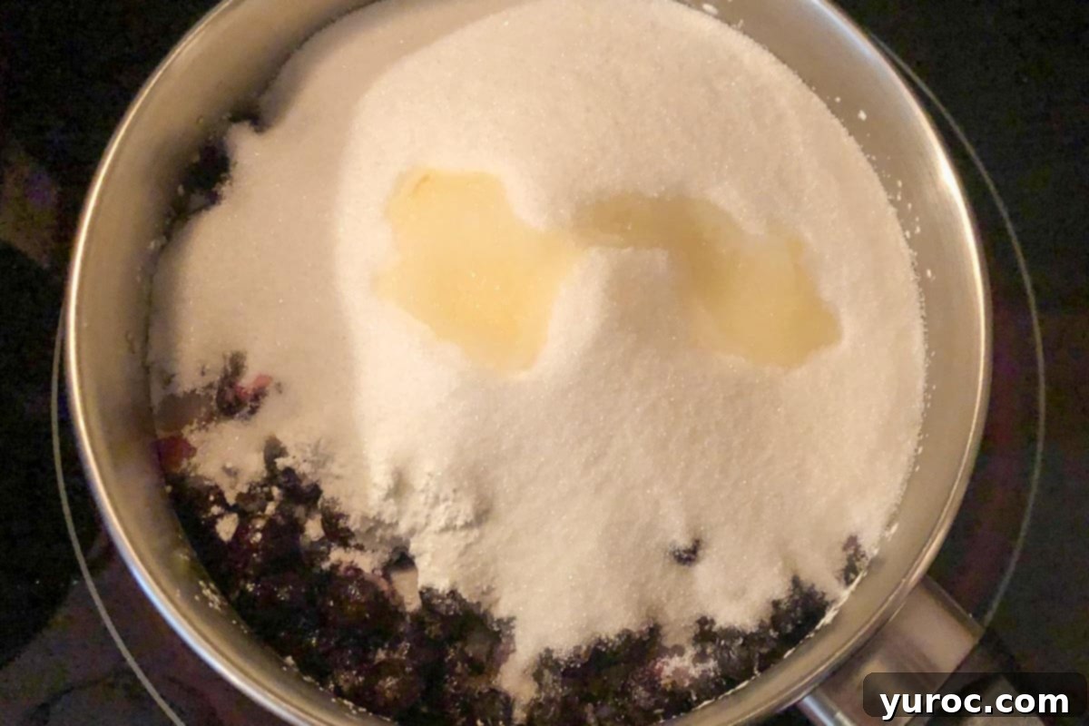 ingredients in Saskatoon berry pie filling in a pot on stove, cooling down