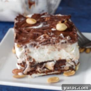 piece of buster bar ice cream cake on white plate with fork and whole glass pan in background