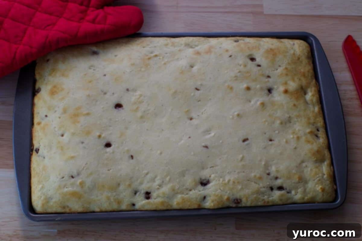 Effortless Sheet Pan Chocolate Chip Pancakes 9 sheet pan pancakes baked on sheet pan with red oven mitt