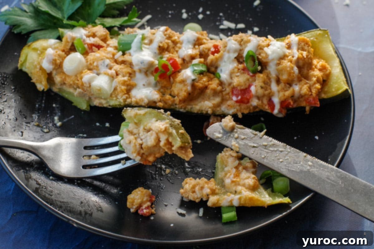 buffalo chicken zucchini boat cut up with piece being held up with fork