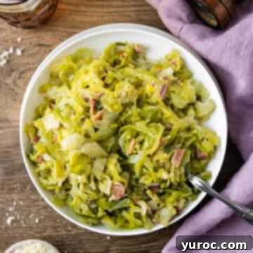 Creamed Cabbage with bacon in a white bowl on a wooden surface, with mauve linen on the side