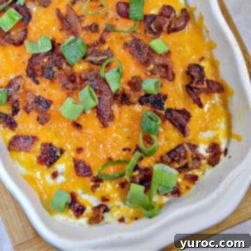 half of a white casserole dish of loaded cauliflower mash