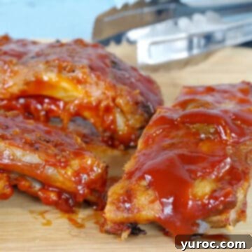 slow cooker ribs with beer on a cutting board with thongs in the background