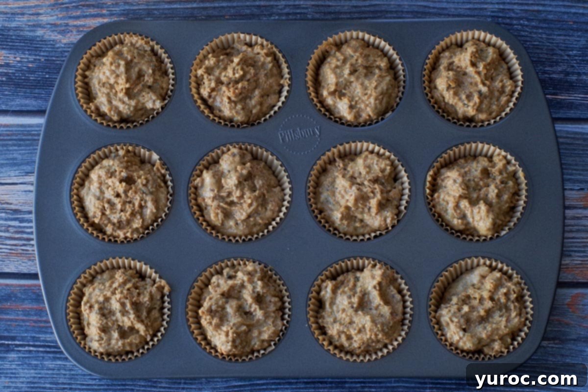 Muffin batter spooned into muffin liners (to the top).