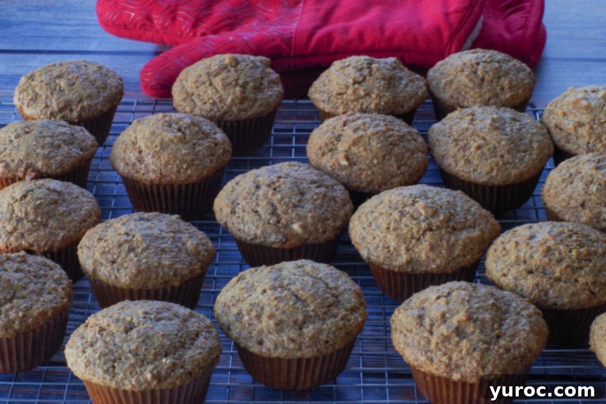 Muffins on cooling rack with red oven mitts in the background.
