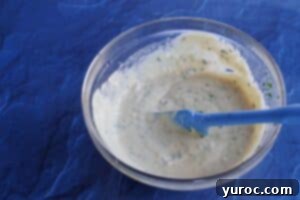 A creamy white dipping sauce in a bowl, with all ingredients perfectly mixed together, ready for serving.