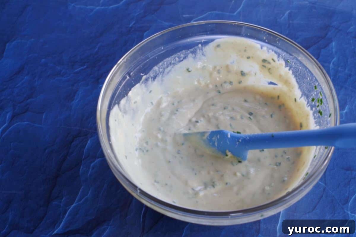 A creamy white dipping sauce in a bowl, with all ingredients perfectly mixed together, ready for serving.