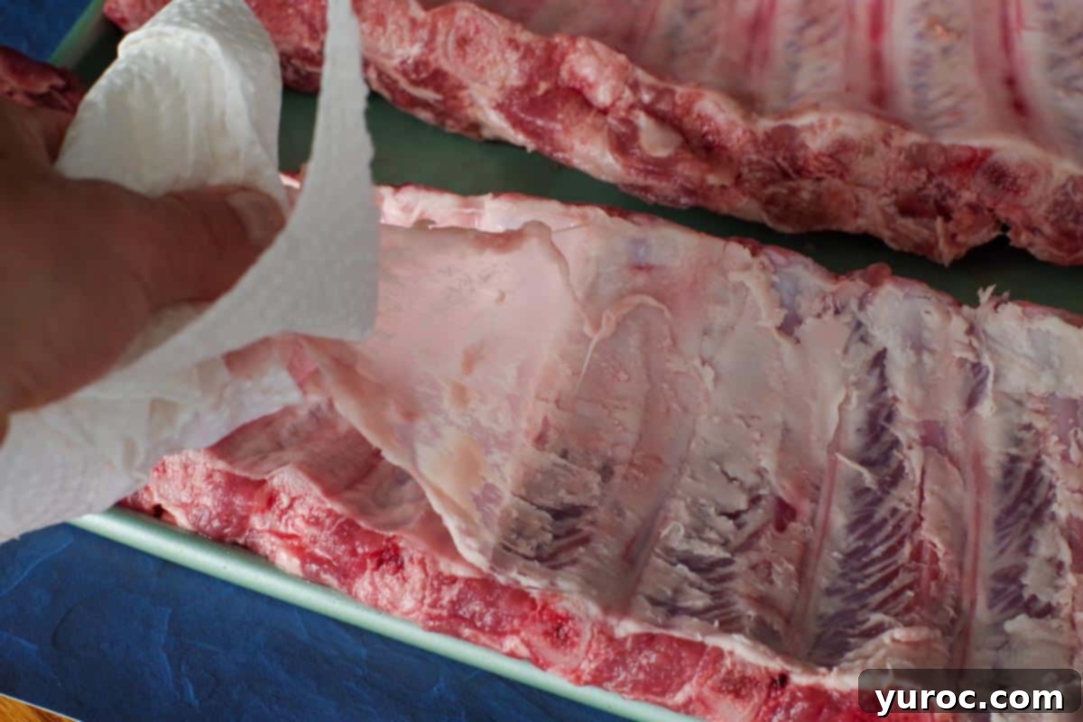 membrane being pulled back from ribs with paper towel