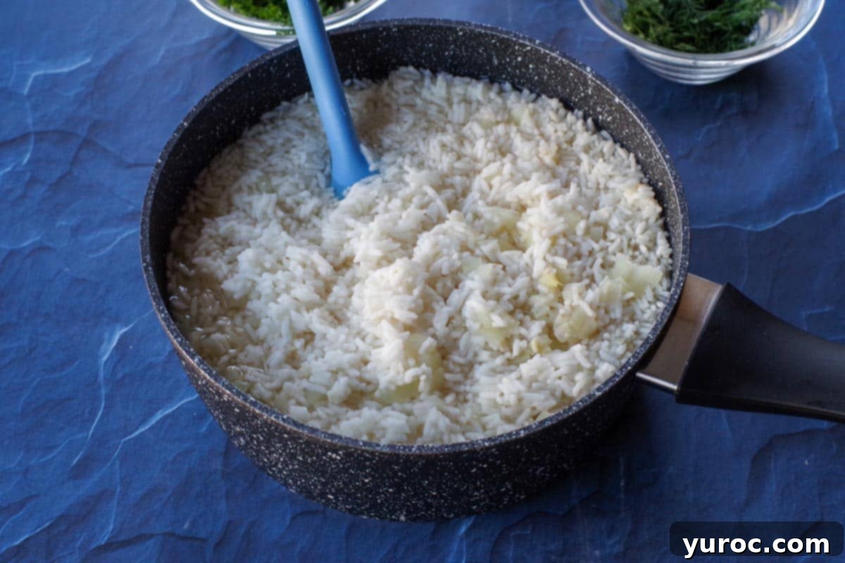 rice with broth, lemon juice, garlic and onion in a black pot