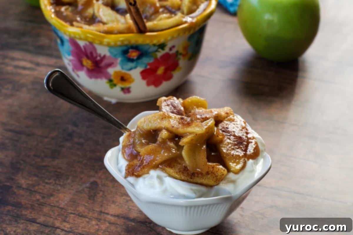 stovetop apple pie filling on top of yogurt in a white bowl, with a spoon in it