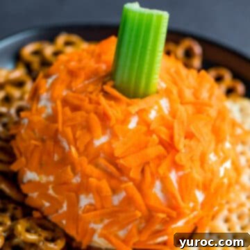 Halloween cheese ball shaped like a pumpkin with celery for a steam and crackers around it