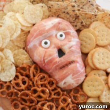 halloween cheese ball surrounded by pretzels, crackers and nachos