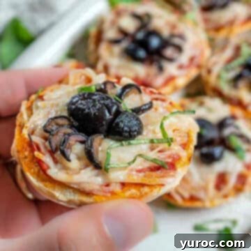 Halloween spider bagel bite being held up with more in the background