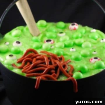 Halloween dessert witches brew trifle, with jello worms in black cauldron, with wooden spoon