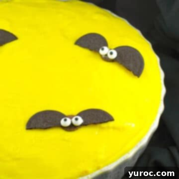 Yellow Moon halloween pie, with chocolate bats in white pie dish, on black surface