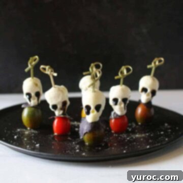 5 halloween caprese skewers on a black plate
